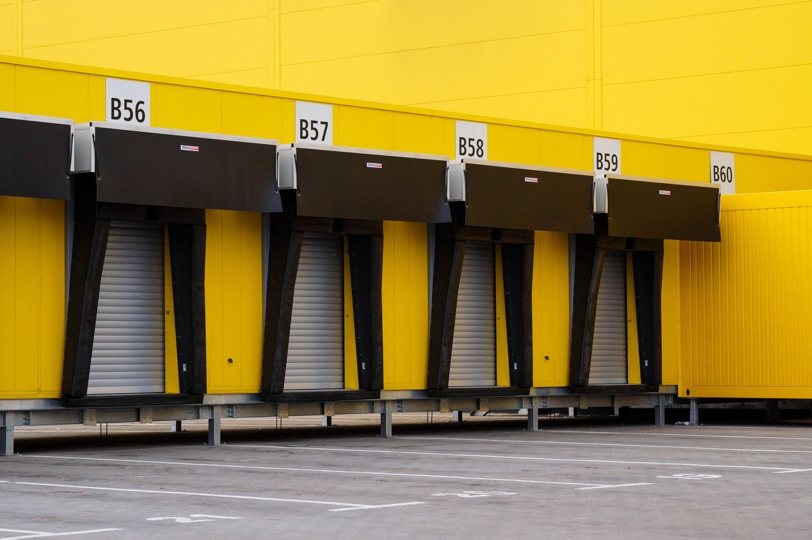 Row of numbered loading dock bays with closed roll-up doors at a commercial warehouse building
