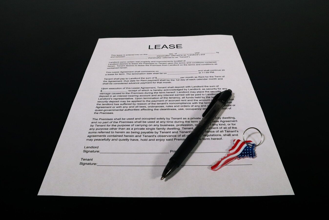 Residential lease agreement on a table with a pen and a key on a keyring