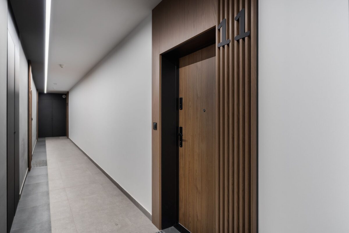 Apartment building corridor with a numbered entrance door and a modern lock