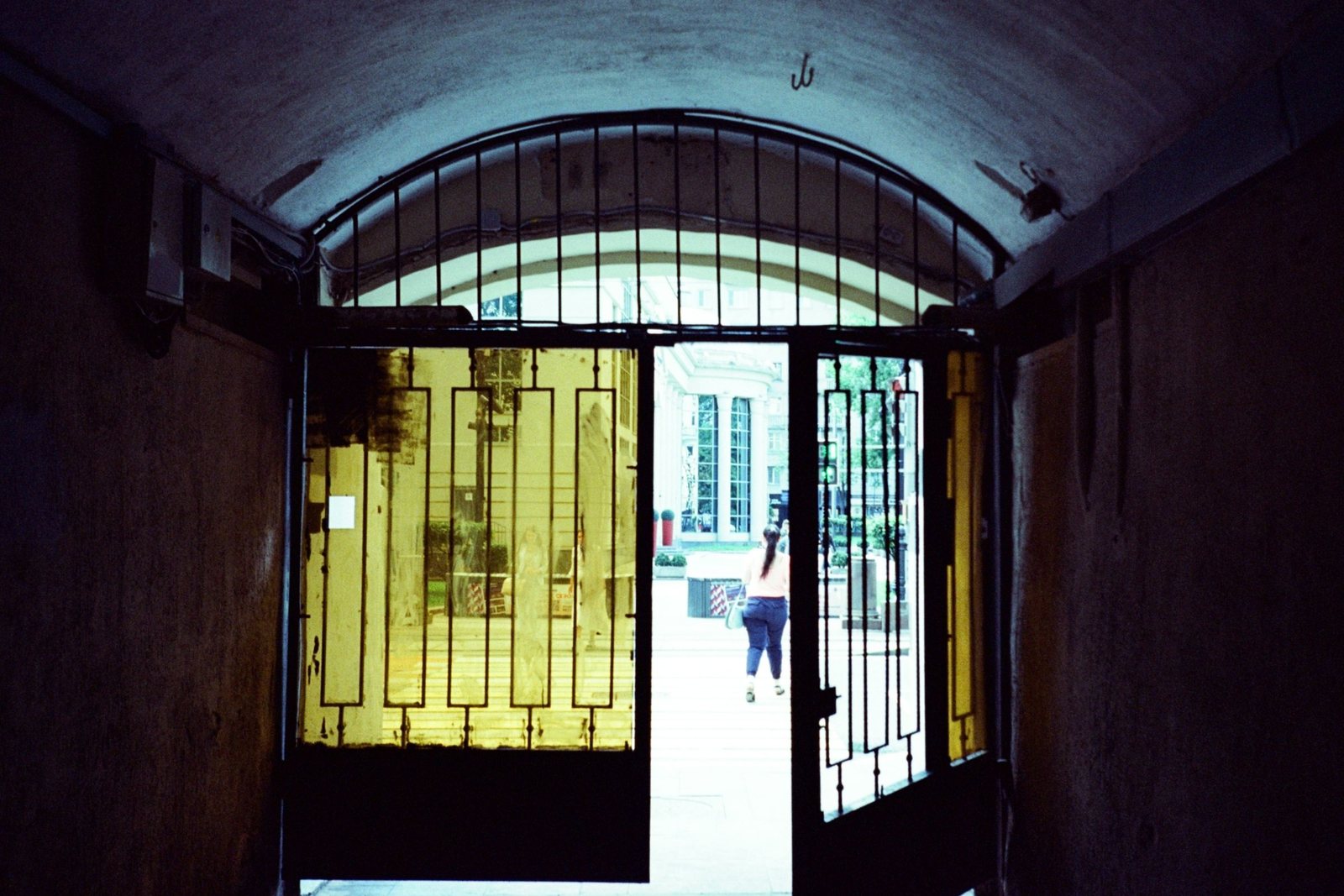 Building entrance door standing open onto the street because the latch no longer catches