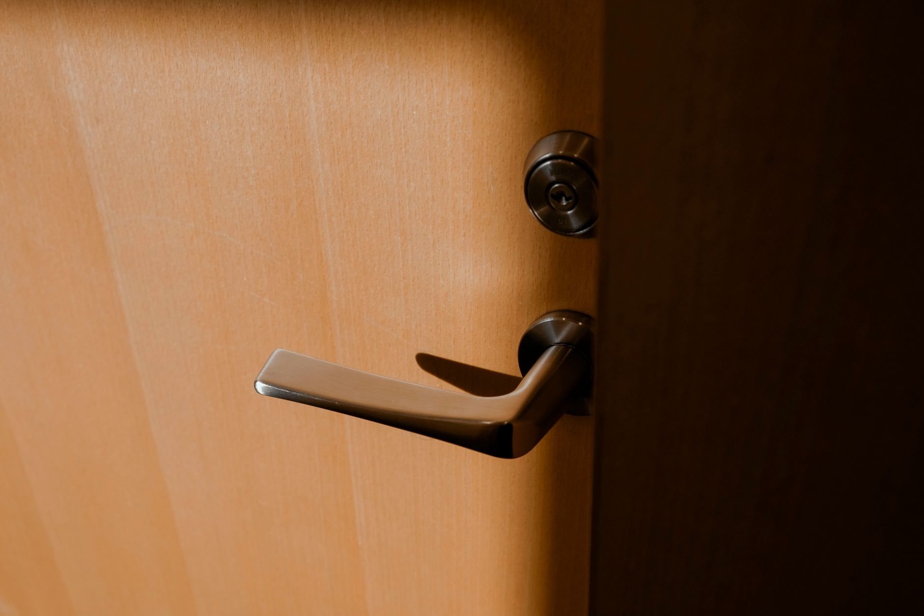 Close-up of a lever handle and cylinder on a door edge, the hardware layout used on the active leaf of a French door