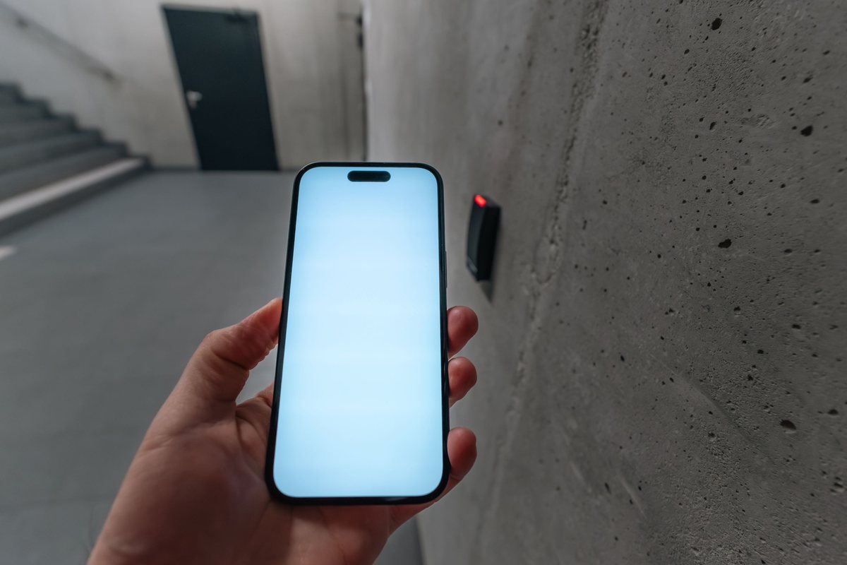 Phone held near a card reader beside a secured stairwell door