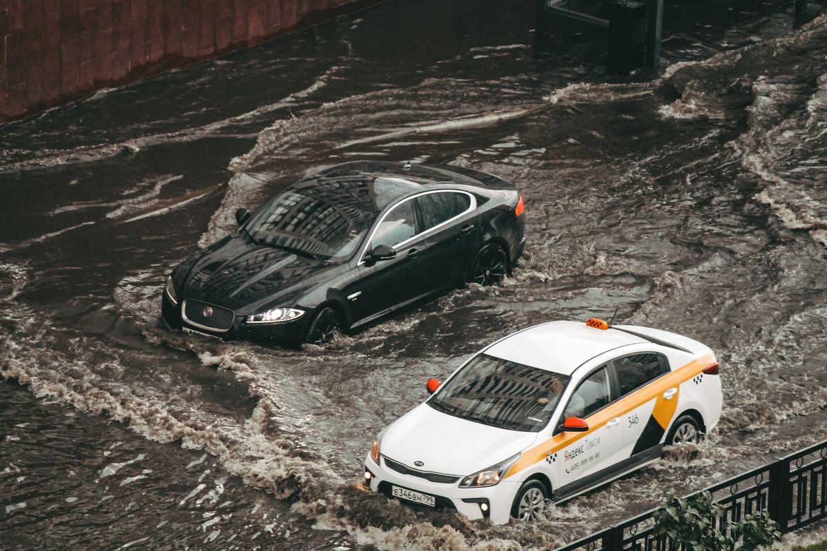 Cars driving through a flooded city street after heavy rain