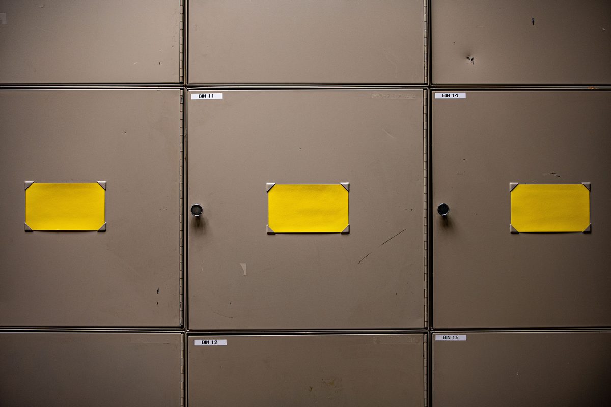 Row of steel office storage cabinets with labelled drawer fronts